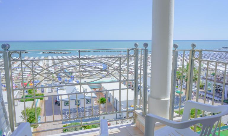 Vista mare con ombrelloni da un balcone.
