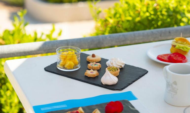 Colazione all'aperto con dolci, frutta e caffè.