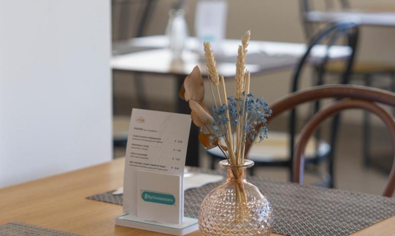 Tavolo da ristorante con decorazioni floreali e menu.