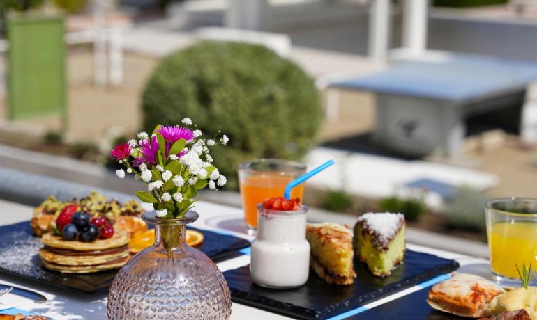 Colazione varia in spiaggia con dolci e bevande.