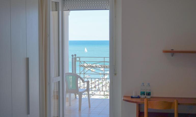 Vista mare da una camera con balcone e sedia.