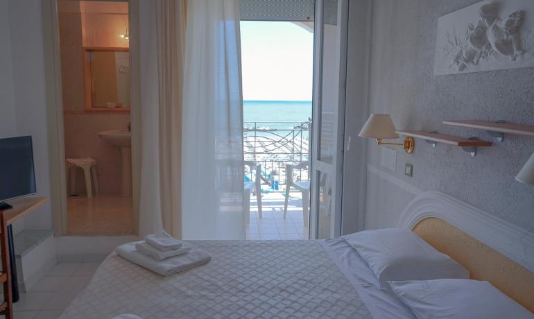 Camera d'albergo con vista mare, bagno e balcone.