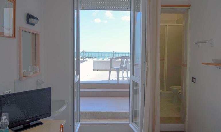 Camera con terrazza vista mare, TV e bagno.