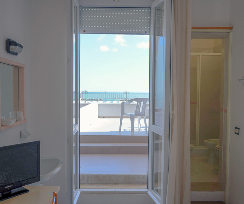 Camera luminosa con vista mare, terrazza e bagno privato.