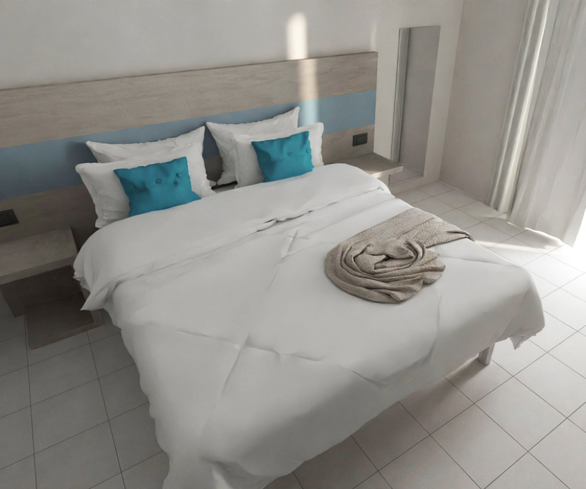Camera minimalista con letto matrimoniale, cuscini blu e coperta grigia su pavimento piastrellato.