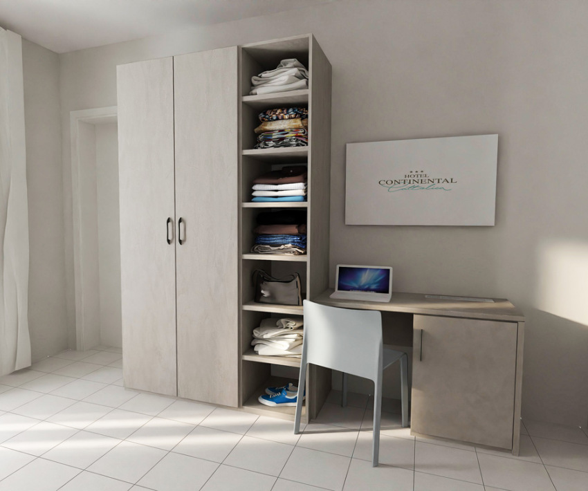 Camera d'albergo con armadio, scrivania, sedia e laptop.